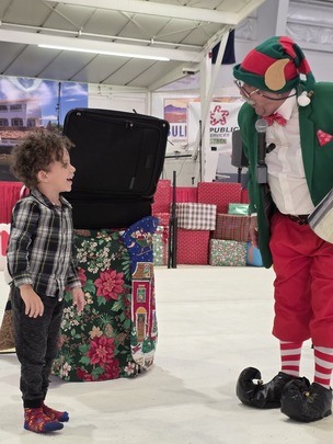 A young boy laughing with Godfrey the Magic Elf at the Winter Festival